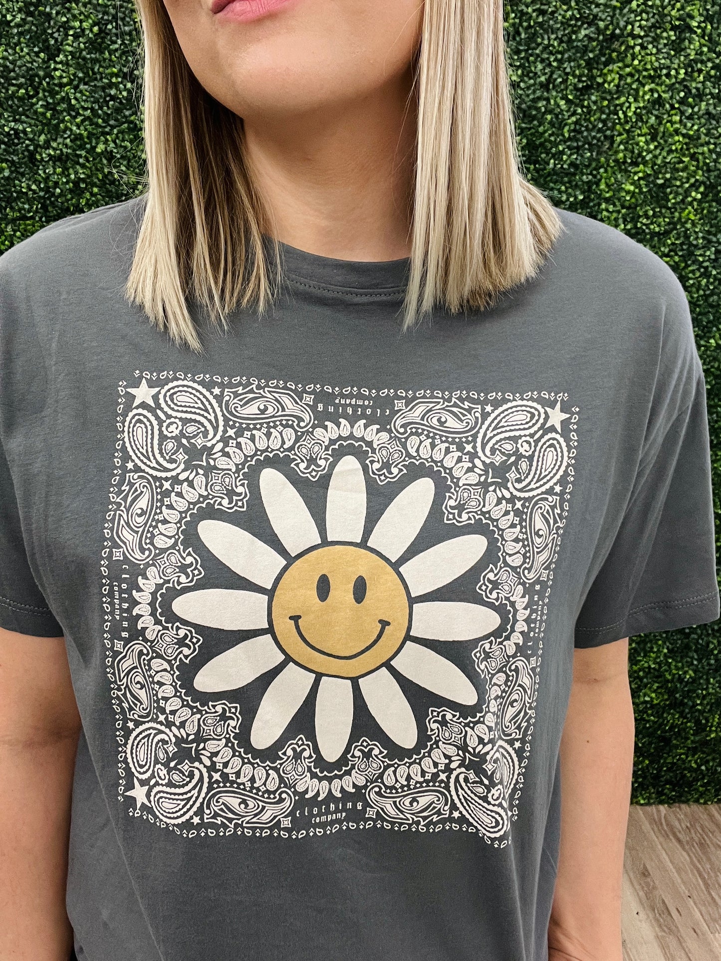 This is a charcoal gray cropped tee with a western floral print. It also features a daisy with a smiley face in the middle. It would pair perfectly with denim and a fun hat! Add some turquoise jewelry to complete the look. 