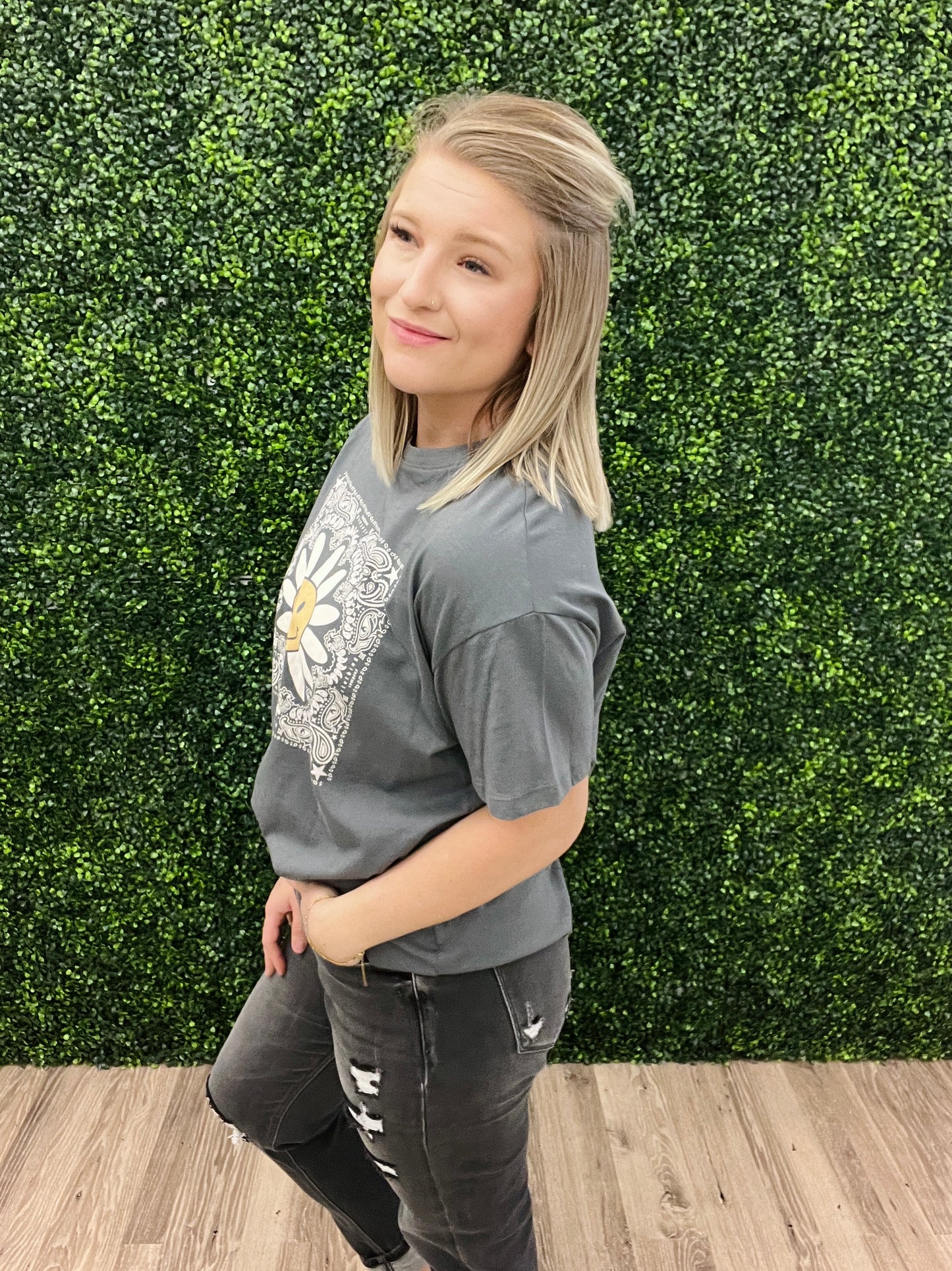 This is a charcoal gray cropped tee with a western floral print. It also features a daisy with a smiley face in the middle. It would pair perfectly with denim and a fun hat! Add some turquoise jewelry to complete the look. 