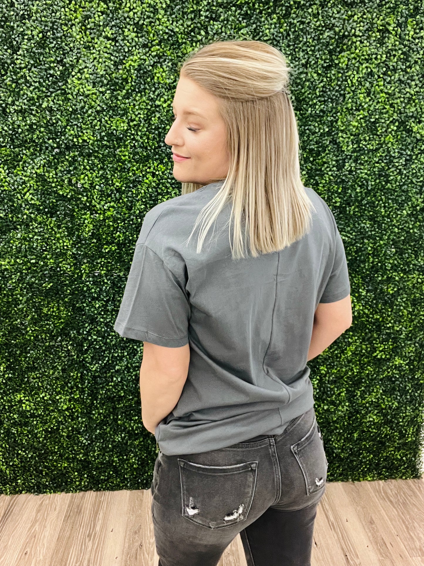 This is a charcoal gray cropped tee with a western floral print. It also features a daisy with a smiley face in the middle. It would pair perfectly with denim and a fun hat! Add some turquoise jewelry to complete the look. 